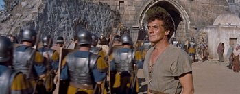 Movie still from “The Robe” (1953), directed by Henry Koster – A group of men in medieval garb in front of a stone wall; Medium shot, Low angle