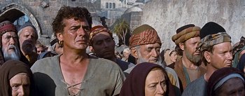 Movie still from “The Robe” (1953), directed by Henry Koster – A group of people standing next to each other on a street; Medium shot, Low angle