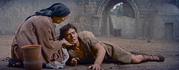 Movie still from “The Robe” (1953), directed by Henry Koster – A man laying on the ground next to a woman; Medium shot, Low angle