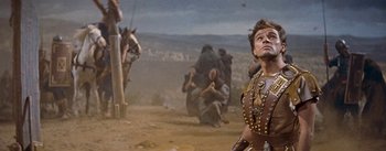 Movie still from “The Robe” (1953), directed by Henry Koster – A man in a costume is looking up at a horse; Medium shot, Low angle