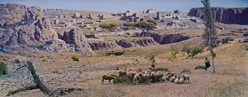 Movie still from “The Robe” (1953), directed by Henry Koster – A herd of sheep grazing on a dry grass field; Extreme Wide shot, High angle