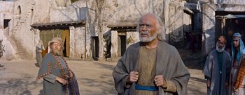 Movie still from “The Robe” (1953), directed by Henry Koster – An old man with a long beard standing in front of a stone building; Medium shot, Low angle