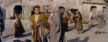 Movie still from “The Robe” (1953), directed by Henry Koster – Two men talking to each other outside in the desert; Medium shot, Over the shoulder angle