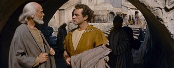 Movie still from “The Robe” (1953), directed by Henry Koster – A man dressed as a roman soldier in a roman outfit; Medium shot, Over the shoulder angle