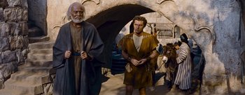 Movie still from “The Robe” (1953), directed by Henry Koster – A man in a brown robe stands next to an older man; Medium shot, Low angle