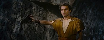 Movie still from “The Robe” (1953), directed by Henry Koster – A man in a brown shirt and a leather arm band; Medium shot, Low angle