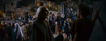 Movie still from “The Robe” (1953), directed by Henry Koster – A group of people gathered around a man in a black robe; Wide shot, High angle