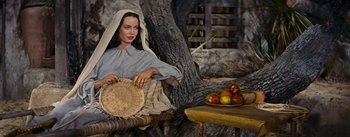 Movie still from “The Robe” (1953), directed by Henry Koster – A painting of a woman sitting on a chair holding a basket of apples; Medium shot, Low angle