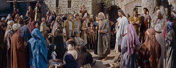 Movie still from “The Robe” (1953), directed by Henry Koster – A group of people gathered around a man in a brown robe; Wide shot, High angle