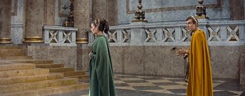 Movie still from “The Robe” (1953), directed by Henry Koster – A woman dressed in a green robe walking through a building; Wide shot, Over the shoulder angle