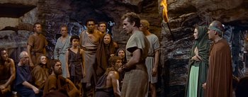 Movie still from “The Robe” (1953), directed by Henry Koster – A group of people in a cave with a man in chains; Wide shot, High angle