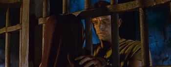 Movie still from “The Robe” (1953), directed by Henry Koster – A man looking through bars of a jail cell; Close Up shot, Low angle