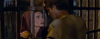 Movie still from “The Robe” (1953), directed by Henry Koster – A man and a woman looking at each other through bars; Close Up shot, Over the shoulder angle