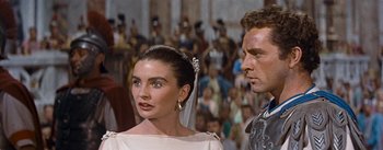 Movie still from “The Robe” (1953), directed by Henry Koster – A man and a woman standing next to each other in a crowd; Close Up shot, Over the shoulder angle