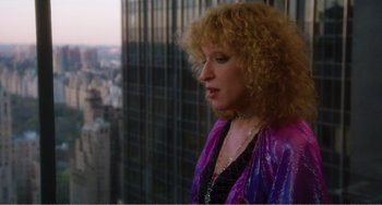 Movie still from “The Rose” (1979), directed by Mark Rydell – A woman standing in front of a window looking out at a city skyline; Medium shot, Low angle