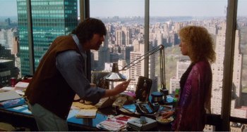 Movie still from “The Rose” (1979), directed by Mark Rydell – A man and a woman in front of a window with a view of a city; Wide shot, Over the shoulder angle