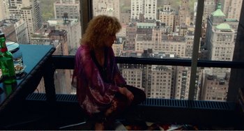 Movie still from “The Rose” (1979), directed by Mark Rydell – A woman sitting on top of a window sill; Wide shot, Overhead angle