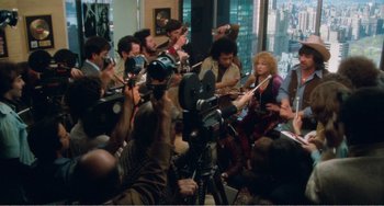 Movie still from “The Rose” (1979), directed by Mark Rydell – A large group of people gathered around a camera; Wide shot, High angle