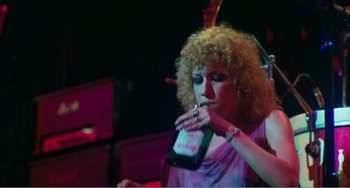 Movie still from “The Rose” (1979), directed by Mark Rydell – A woman holding a cell phone in her hand; Medium shot, High angle