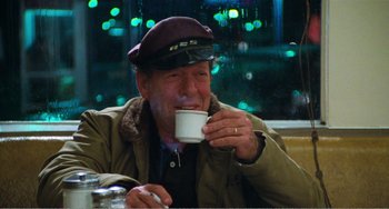 Movie still from “The Rose” (1979), directed by Mark Rydell – An older man drinking a cup of coffee; Medium shot, Over the shoulder angle