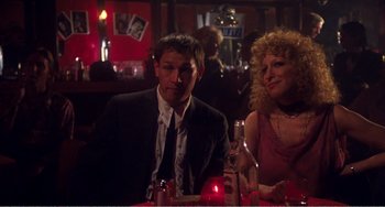Movie still from “The Rose” (1979), directed by Mark Rydell – A man and a woman sitting at a dinner table; Medium shot, Low angle