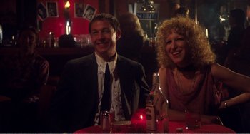 Movie still from “The Rose” (1979), directed by Mark Rydell – A man and a woman sitting at a dinner table; Medium shot, Low angle