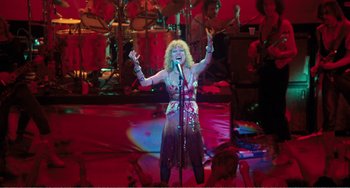 Movie still from “The Rose” (1979), directed by Mark Rydell – A woman is singing on a stage in front of an audience; Wide shot, Low angle