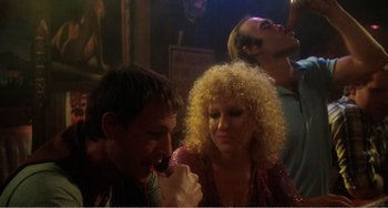 Movie still from “The Rose” (1979), directed by Mark Rydell – A man and a woman are eating a donut; Medium shot, Low angle