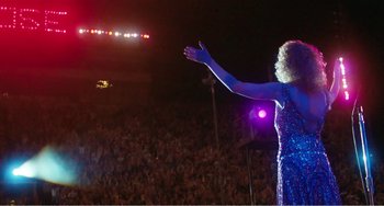 Movie still from “The Rose” (1979), directed by Mark Rydell – A woman in a blue dress is on a stage; Wide shot, High angle