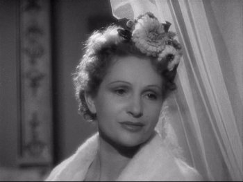 Movie still from “The Rules of the Game” (1939), directed by Jean Renoir – A black and white photo of a woman with a flower in her hair; Close Up shot, Over the shoulder angle