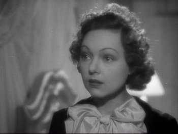 Movie still from “The Rules of the Game” (1939), directed by Jean Renoir – An old black and white photo of a woman in a bow tie; Close Up shot, High angle