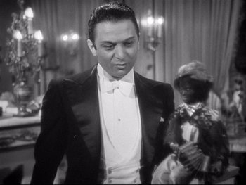 Movie still from “The Rules of the Game” (1939), directed by Jean Renoir – A man in a tuxedo standing next to a woman in a black dress; Medium shot, High angle