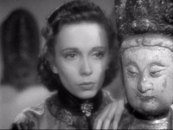 Movie still from “The Rules of the Game” (1939), directed by Jean Renoir – An old photo of a woman and a buddha statue; Close Up shot, Low angle