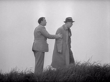 Movie still from “The Rules of the Game” (1939), directed by Jean Renoir – Two men are walking in a grassy field; Medium shot, Low angle