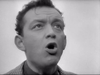 Movie still from “The Rules of the Game” (1939), directed by Jean Renoir – An old black and white photo of a man with a surprised look on his face; Close Up shot, Low angle