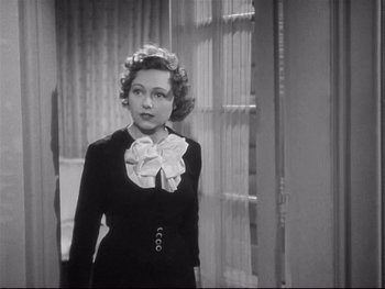 Movie still from “The Rules of the Game” (1939), directed by Jean Renoir – A woman in a black dress and a white bow tie; Medium shot, Over the shoulder angle