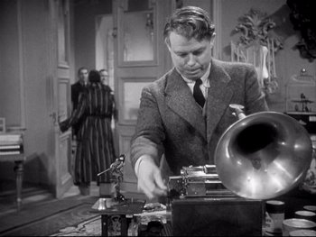 Movie still from “The Rules of the Game” (1939), directed by Jean Renoir – An old photo of a man using an old gramaphone; Medium shot, Low angle