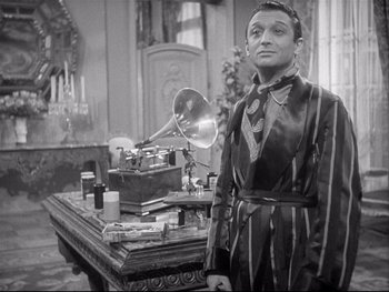 Movie still from “The Rules of the Game” (1939), directed by Jean Renoir – A man standing in front of a table with gramophones on top of it; Medium shot, High angle