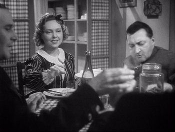 Movie still from “The Rules of the Game” (1939), directed by Jean Renoir – An older woman sitting at a table with a plate of food in front of a man; Medium shot, Over the shoulder angle