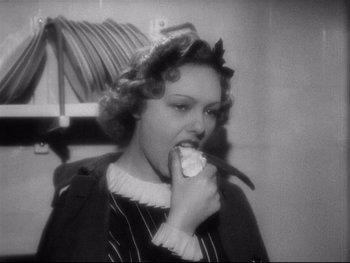 Movie still from “The Rules of the Game” (1939), directed by Jean Renoir – An old photo of a woman eating a piece of food; Close Up shot, High angle