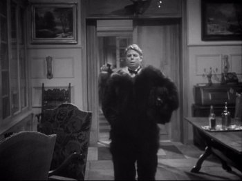 Movie still from “The Rules of the Game” (1939), directed by Jean Renoir – A black and white photo of a man in a suit and tie; Medium shot, Low angle