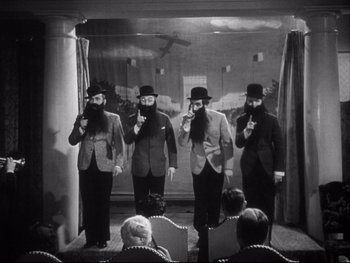 Movie still from “The Rules of the Game” (1939), directed by Jean Renoir – A group of men standing next to each other in a room; Medium shot, High angle