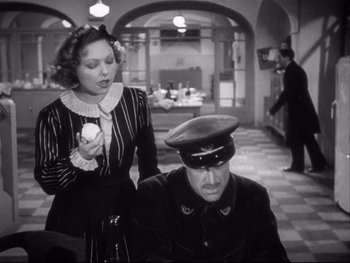 Movie still from “The Rules of the Game” (1939), directed by Jean Renoir – An old photo of a woman and a man in uniform; Medium shot, Over the shoulder angle