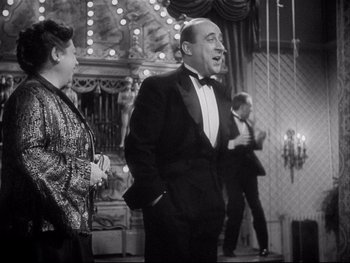 Movie still from “The Rules of the Game” (1939), directed by Jean Renoir – A black and white photo of a man and a woman; Medium shot, Low angle