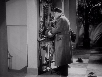 Movie still from “The Rules of the Game” (1939), directed by Jean Renoir – A black and white photo of a man looking at a mirror; Medium shot, Low angle