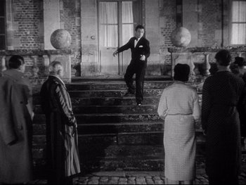 Movie still from “The Rules of the Game” (1939), directed by Jean Renoir – An old photo of a man on some steps; Wide shot, Low angle