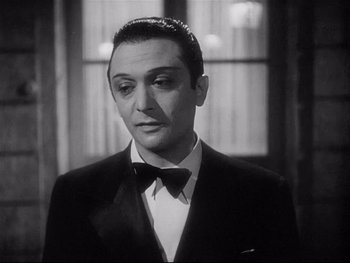 Movie still from “The Rules of the Game” (1939), directed by Jean Renoir – A black and white photo of a man in a tuxedo; Close Up shot, Over the shoulder angle