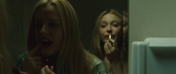 Movie still from “The Runaways” (2010), directed by Floria Sigismondi – A woman is looking at herself in the mirror while smoking a cigarette; Close Up shot, Low angle