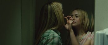 Movie still from “The Runaways” (2010), directed by Floria Sigismondi – A woman looking in the mirror while putting makeup on her face; Close Up shot, Over the shoulder angle