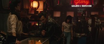 Movie still from “The Runaways” (2010), directed by Floria Sigismondi – A man and a woman are walking in a bar; Medium shot, Over the shoulder angle